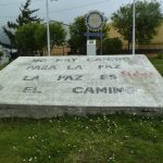 Das Bild zeigt eine große Steinplatte in Ushuhaia, einer Stadt am südlichen Ende des südamerikanischen Kontinents. Auf der Platte steht "No Hay Camino Para La Paz, La Paz Es El Camino" was auf deutsch bedeutet "Es gibt keinen Weg zum Frieden, der Friede ist der Weg". Die Platte steht auf einer Wiese, hinter der Platte ist ein Zeichen des Rotary-Clubs aufgestellt.